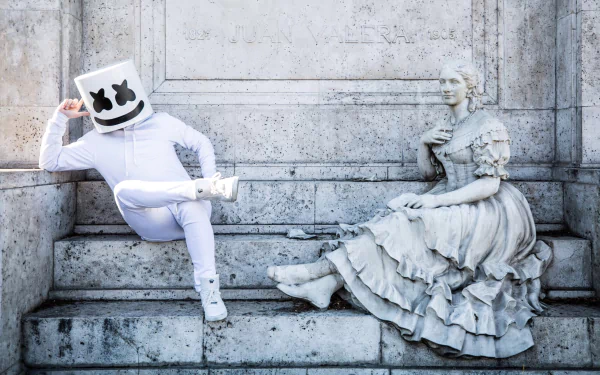 HD wallpaper of Marshmello sitting next to a statue on steps, providing a modern and classical visual contrast.