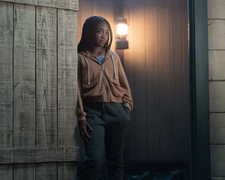 HD desktop wallpaper of a character from Percy Jackson and the Olympians standing confidently in a dimly lit hallway.