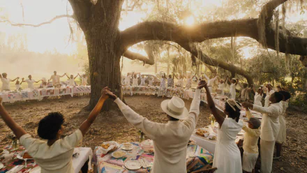 HD wallpaper featuring a scene from the 2023 adaptation of The Color Purple, with people dressed in white celebrating outdoors under a large tree with sunlight filtering through the branches.