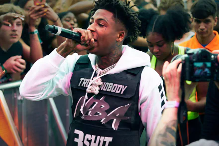 Music artist performing live in front of a crowd, captured as an HD desktop wallpaper and background tagged with YoungBoy Never Broke Again.