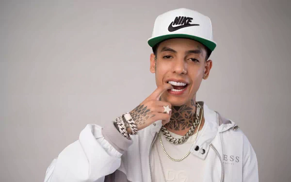 HD desktop wallpaper featuring a stylish individual wearing a white Nike cap and jacket with distinctive tattoos and jewelry, posing with a confident smile against a grey background.