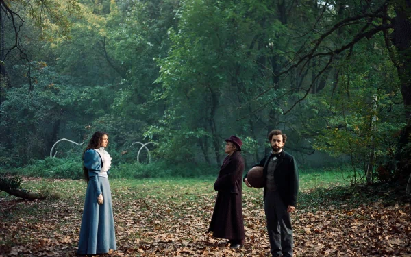 HD desktop wallpaper featuring characters from the movie 'Poor Things' set in a misty, leaf-strewn forest.