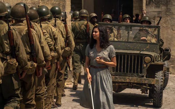 HD wallpaper featuring a scene from the TV show All the Light We Cannot See with a young woman holding a white cane in the foreground, and soldiers with a military jeep in the background.