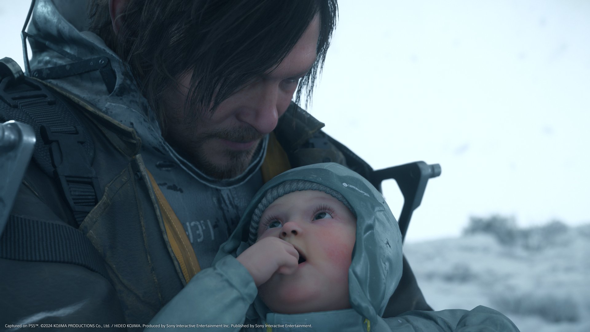 HD wallpaper of a scene from Death Stranding 2: On The Beach featuring a character holding a baby in a snowy environment.