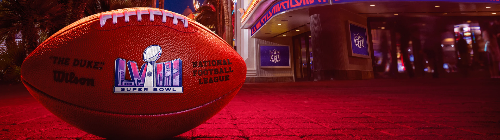 A close-up of a Super Bowl football with the NFL logo, set against a vibrant urban background, making this HD wallpaper a striking tribute to football and sports.