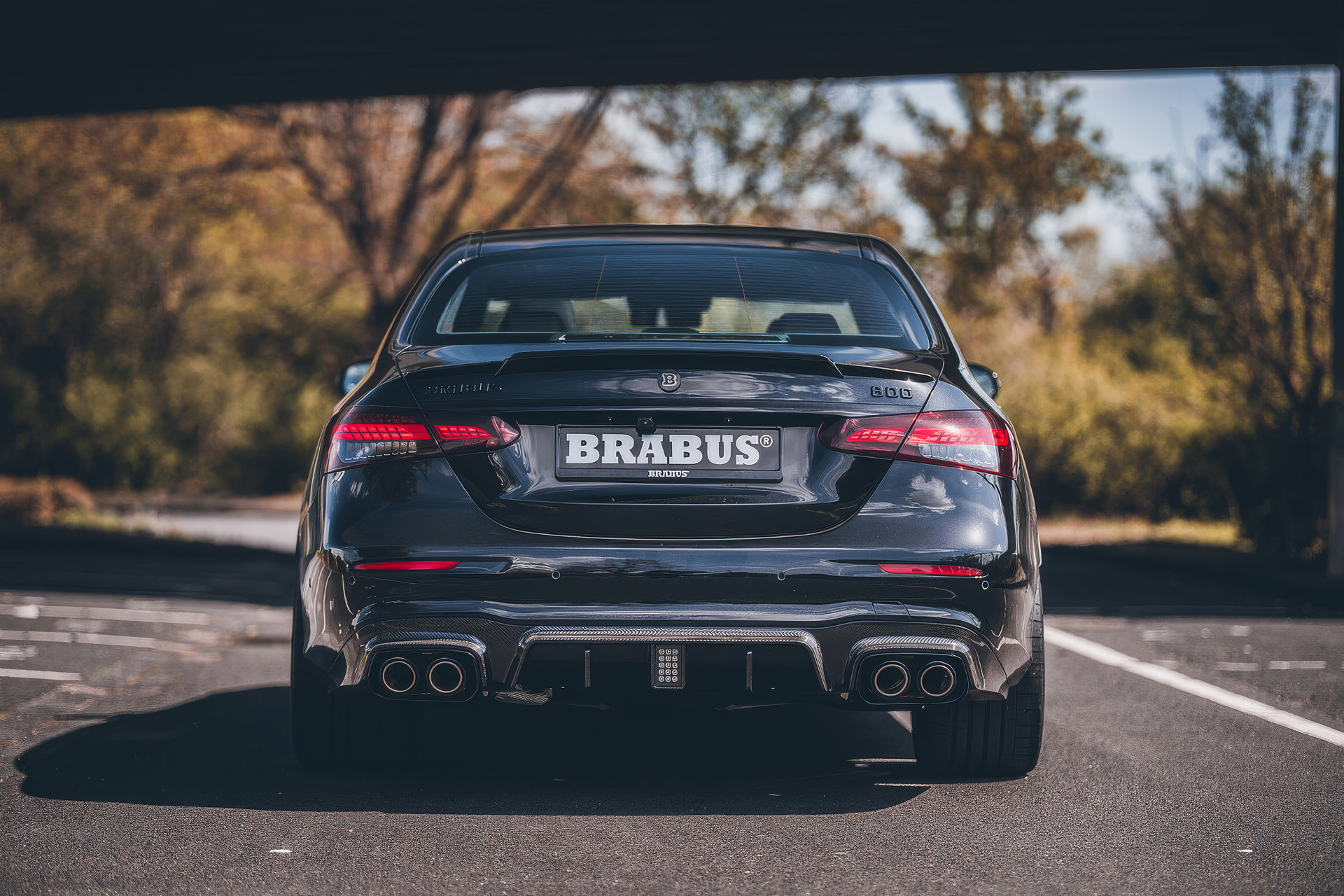 Brabus 800 E63 car showcased as an HD desktop wallpaper, featuring the powerful vehicle's rear view parked under a bridge.
