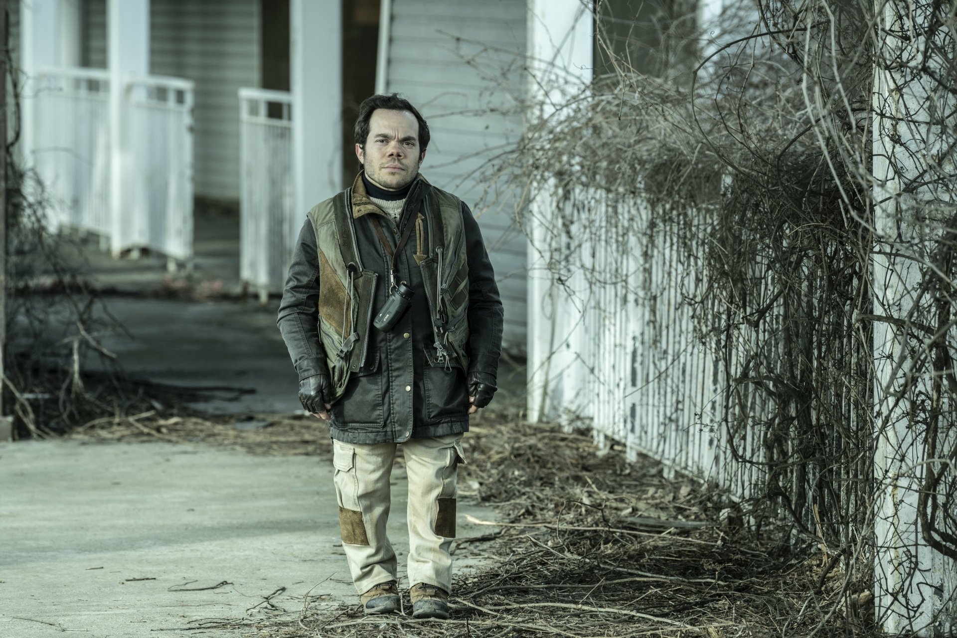 Character from The Walking Dead: The Ones Who Live standing on a desolate street in HD desktop wallpaper background.