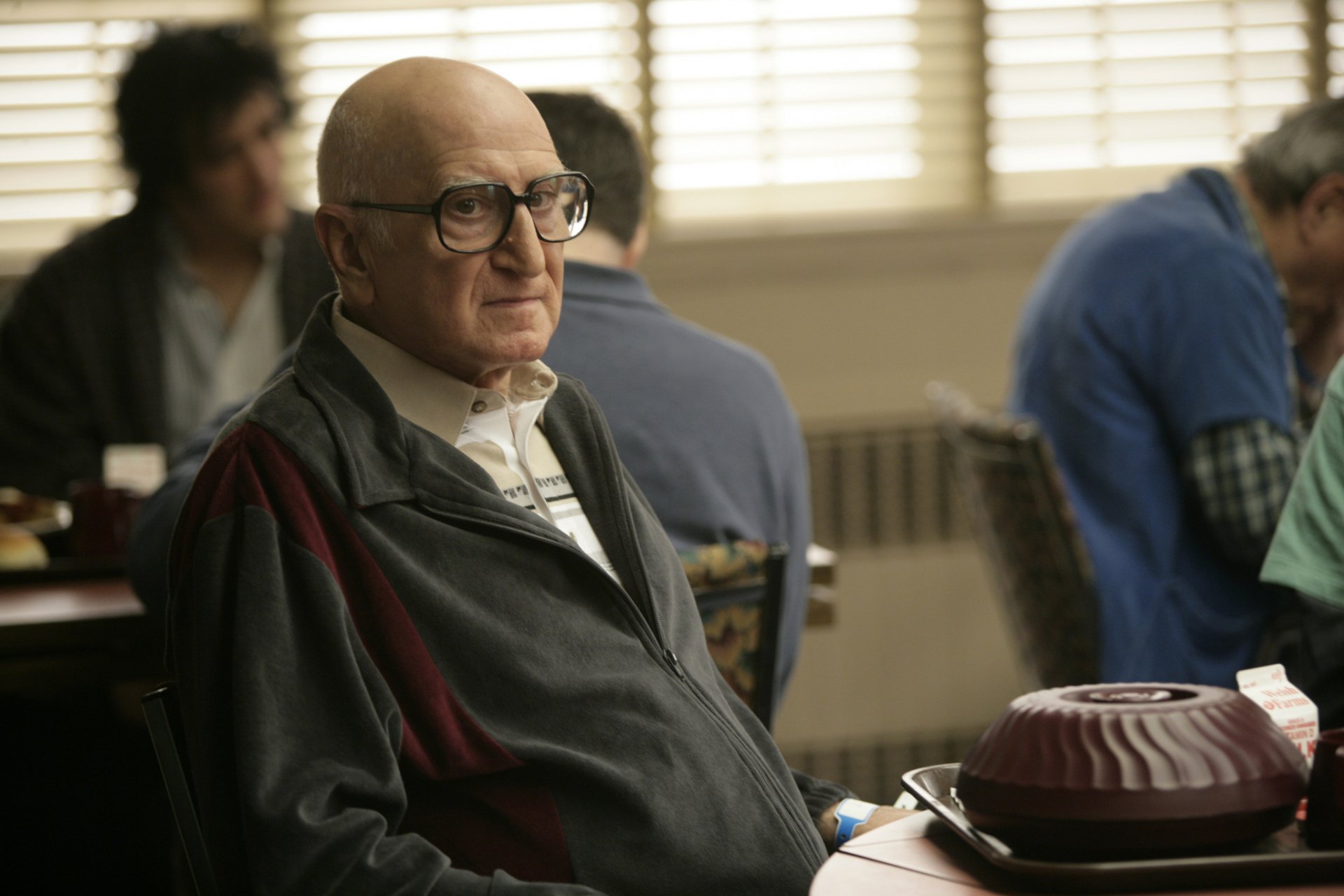 HD wallpaper featuring a scene from the TV show The Sopranos, with a character sitting in a diner environment looking pensive.