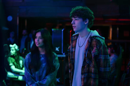 HD wallpaper featuring a scene from 'The Family Plan' movie with two characters in a vibrant, neon-lit setting.