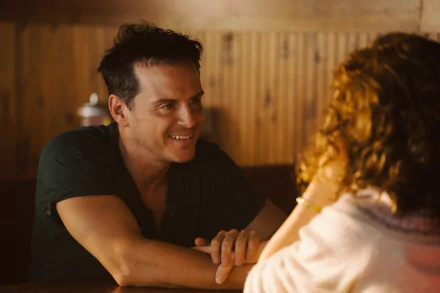 A scene from the movie All of Us Strangers, showing a man and woman engaged in an intimate conversation, captured as a stunning HD desktop wallpaper.