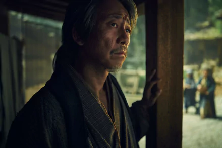 HD Wallpaper featuring a dramatic scene from the 2024 TV show Shogun with a contemplative character in traditional garb looking out from a wooden doorway.