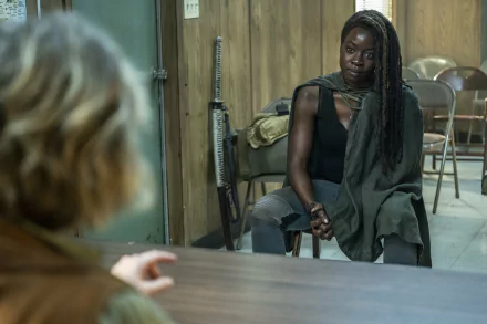 HD desktop wallpaper from The Walking Dead: The Ones Who Live featuring a focused Michonne seated at a table.