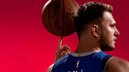 HD wallpaper featuring a Dallas Mavericks player poised with a basketball against a vibrant red background, capturing the intensity of NBA action.