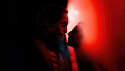 HD desktop wallpaper featuring a stylized artistic representation related to the movie Joker: Folie à Deux, depicting two silhouettes with Joker-like makeup in red and black tones, facing each other intimately against a dark background.