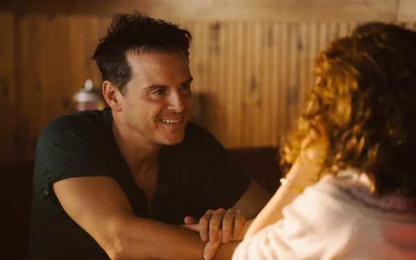 A scene from the movie All of Us Strangers, showing a man and woman engaged in an intimate conversation, captured as a stunning HD desktop wallpaper.