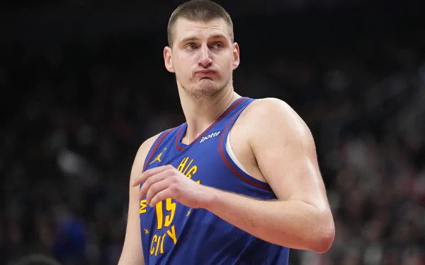 Nikola Jokić of the Denver Nuggets poses confidently in this HD desktop wallpaper, showcasing his dynamic presence on the court.