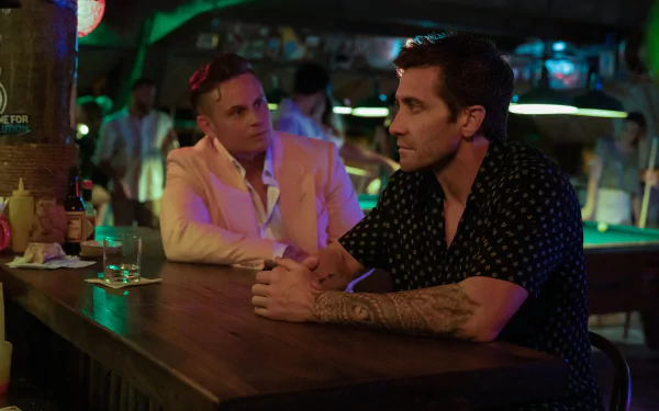 HD wallpaper featuring a scene from the 2024 movie Road House with Jake Gyllenhaal sitting at a bar.