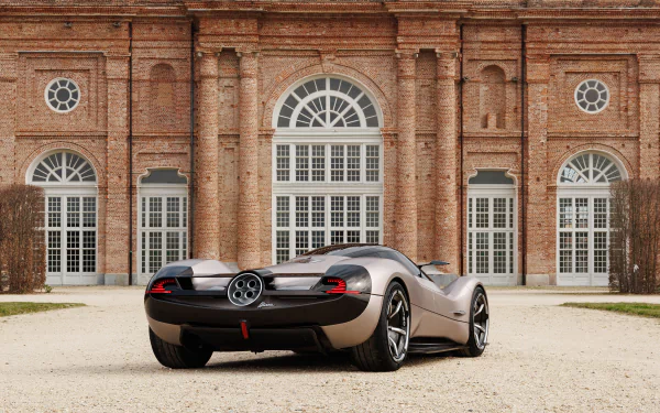A Pagani Huayra parked in front of an elegant brick building with large windows and arching doorways, suitable as a high-definition desktop wallpaper and background.