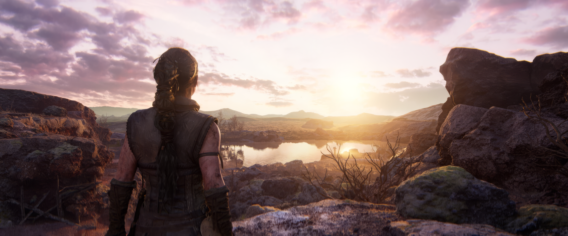 A high-definition desktop wallpaper featuring a scene from the video game Senua's Saga: Hellblade II, showcasing a character looking over a serene, sunlit landscape.