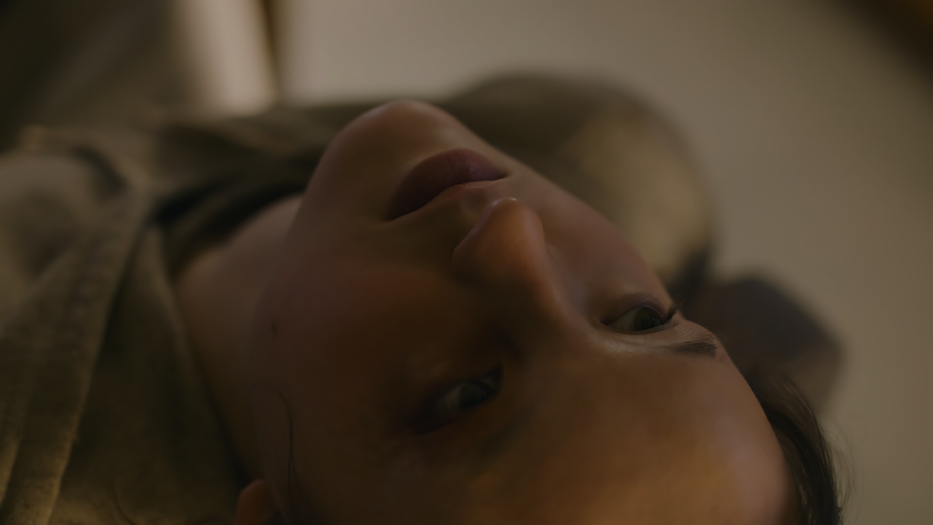 Close-up of a woman lying down with a somber expression, captured in 8K Ultra HD as a PC desktop wallpaper background inspired by The Last Of Us.