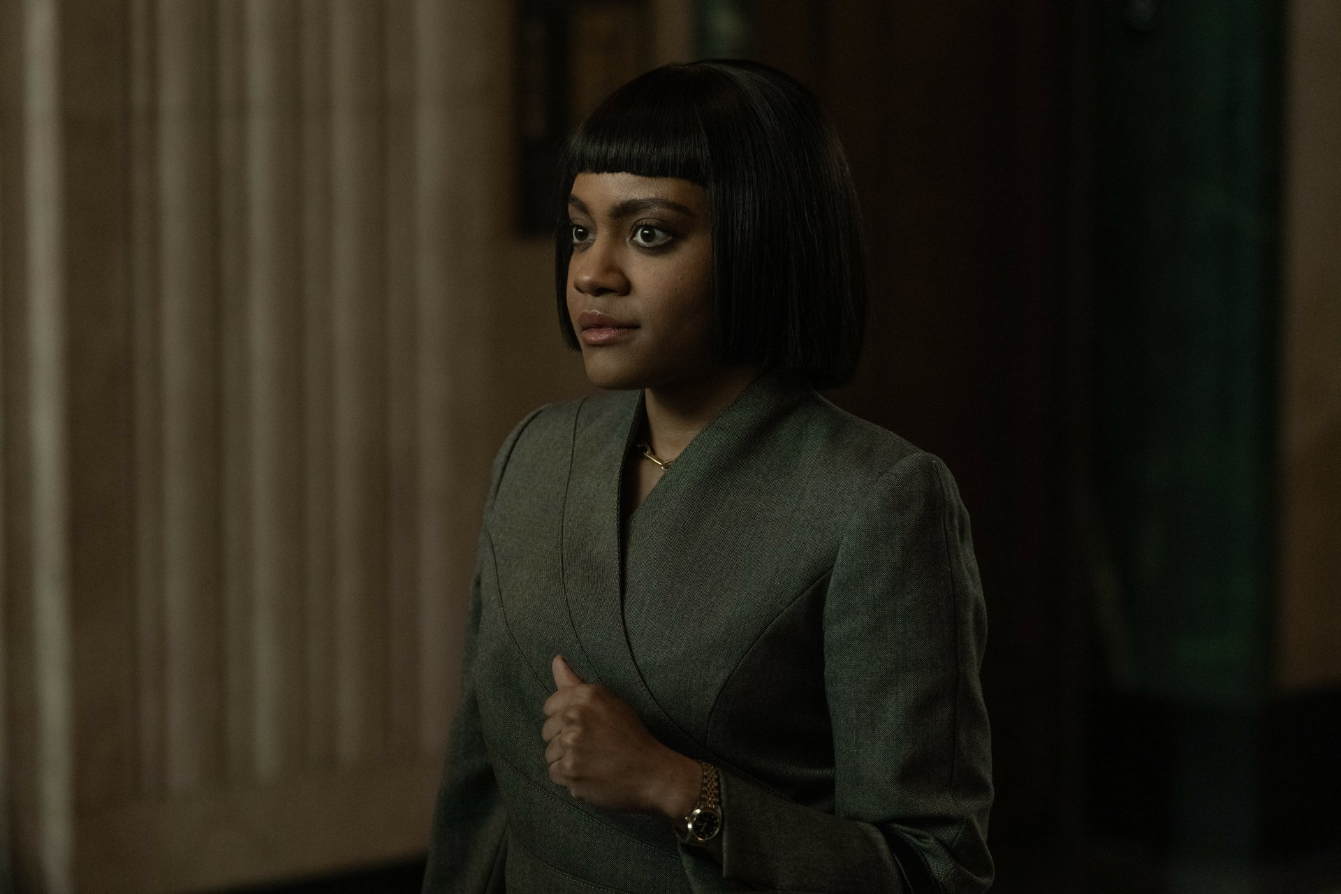 A HD desktop wallpaper featuring a character from the TV show Presumed Innocent (2024), showcasing a woman standing confidently inside a dimly lit building.