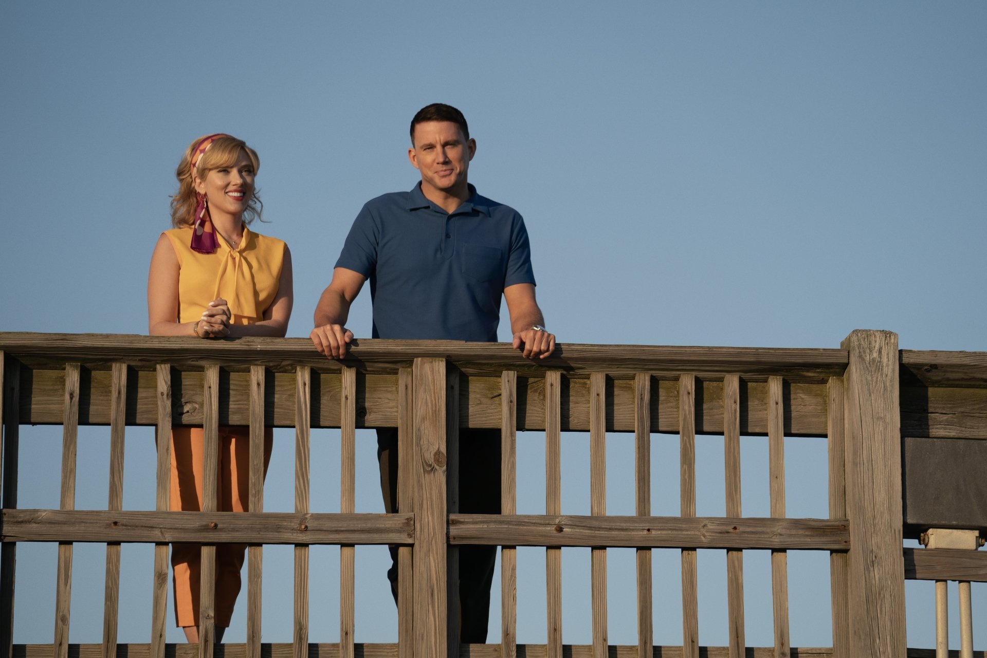 Scarlett Johansson and Channing Tatum from the movie Fly Me to the Moon (2024) stand on a wooden bridge in this HD desktop wallpaper and background.