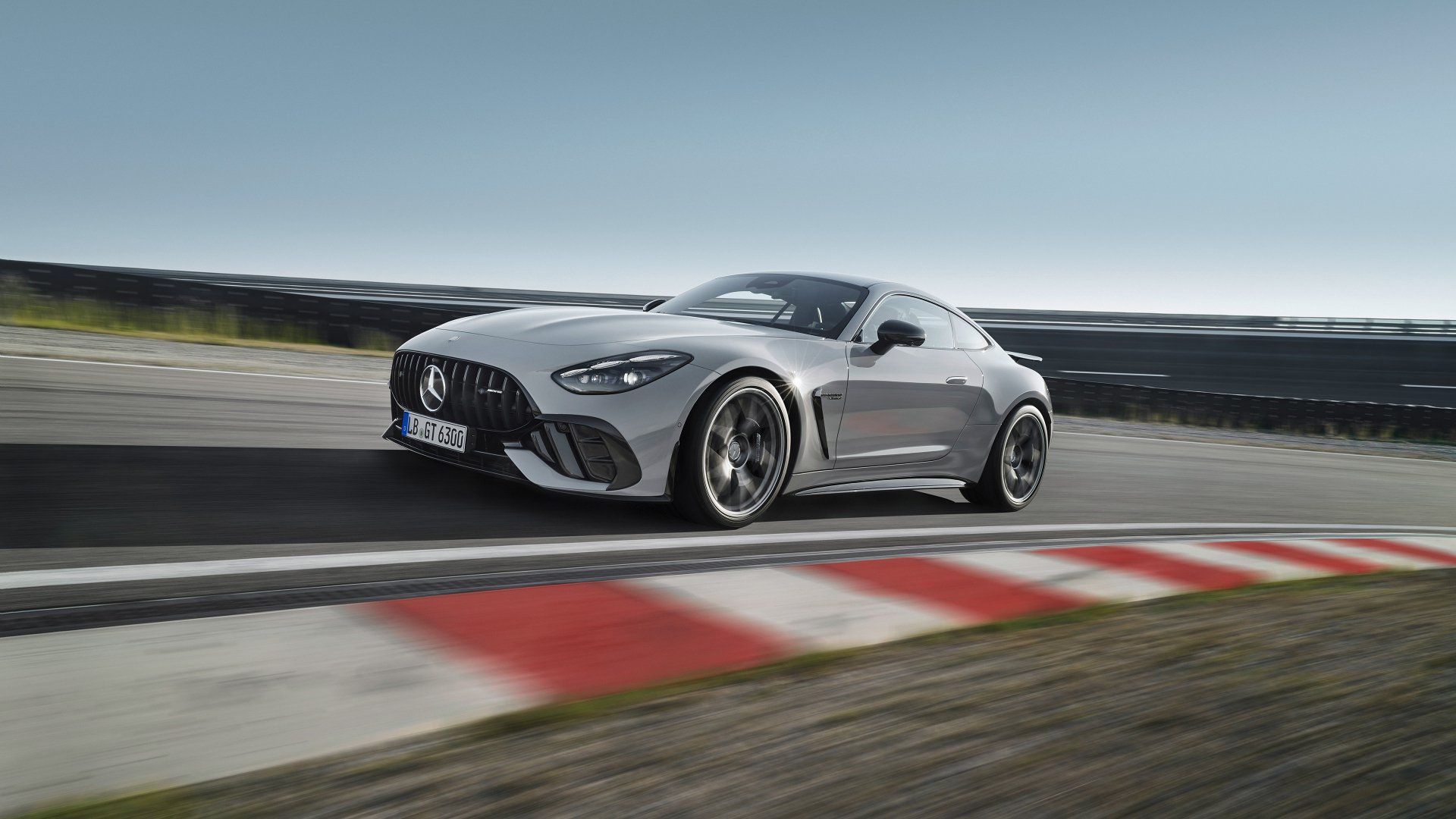 An HD desktop wallpaper and background featuring a silver Mercedes-AMG GT63 PRO speeding on a race track, showcasing its sleek design and performance.
