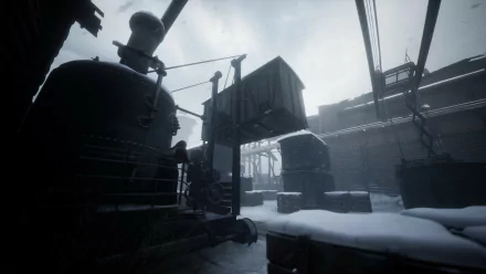 HD desktop wallpaper from the video game Indika, featuring a snowy train yard with a locomotive and cargo crates in a dim, wintry setting.