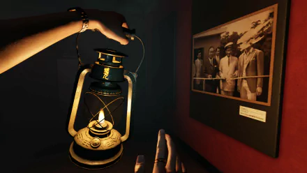 A screenshot from The Bridge Curse 2: The Extrication video game, featuring a hand holding a lit lantern next to a historical photo in a dimly-lit room. High-definition desktop wallpaper and background.