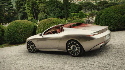 HD desktop wallpaper featuring a sleek BMW Skytop parked on a gravel path surrounded by lush greenery.