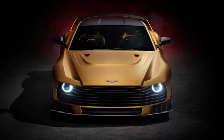 HD desktop wallpaper featuring a front view of a gold Aston Martin Valiant, showcasing its sleek design and illuminated headlights against a dark background.