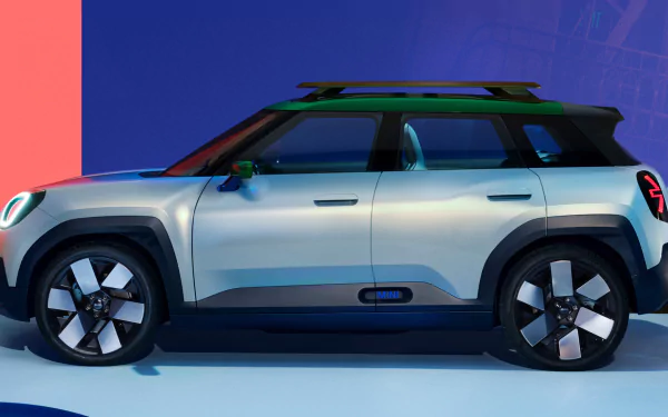 HD desktop wallpaper featuring a side view of a silver MINI Aceman car with stylish wheels on a blue and pink gradient background.