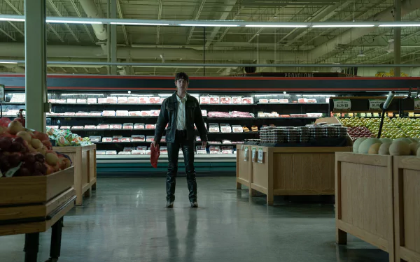 HD desktop wallpaper from the movie I Saw the TV Glow, featuring a man standing in a grocery store aisle.