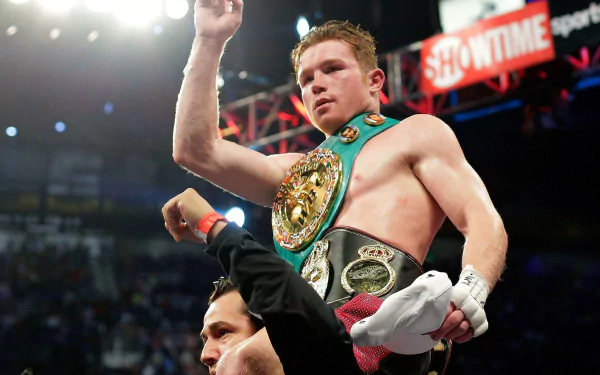 HD wallpaper of boxer Canelo Álvarez celebrating a victory in the ring, lifted triumphantly with a championship belt.