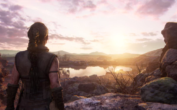 A high-definition desktop wallpaper featuring a scene from the video game Senua's Saga: Hellblade II, showcasing a character looking over a serene, sunlit landscape.