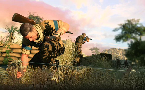HD desktop wallpaper featuring a scene from the video game Sniper Elite III. Two soldiers are crouched, aiming with rifles amidst a rugged landscape under a pink-tinged sky.