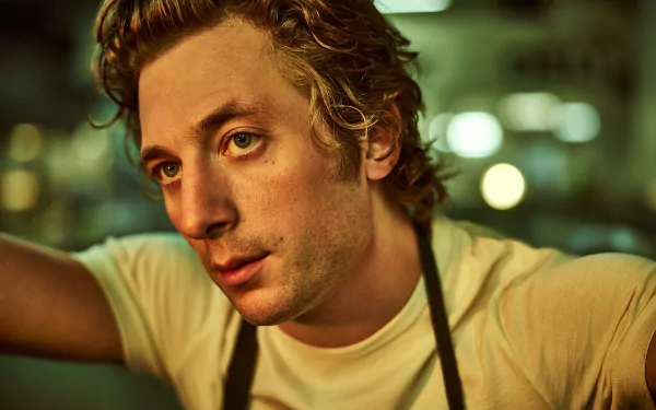 HD desktop wallpaper featuring Jeremy Allen White from the TV show The Bear, captured in a candid moment with a blurred background.