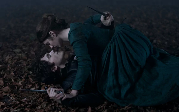 A dramatic scene from the movie My Lady Jane, featuring two characters in an intense moment on a forest floor, serves as an HD desktop wallpaper and background.