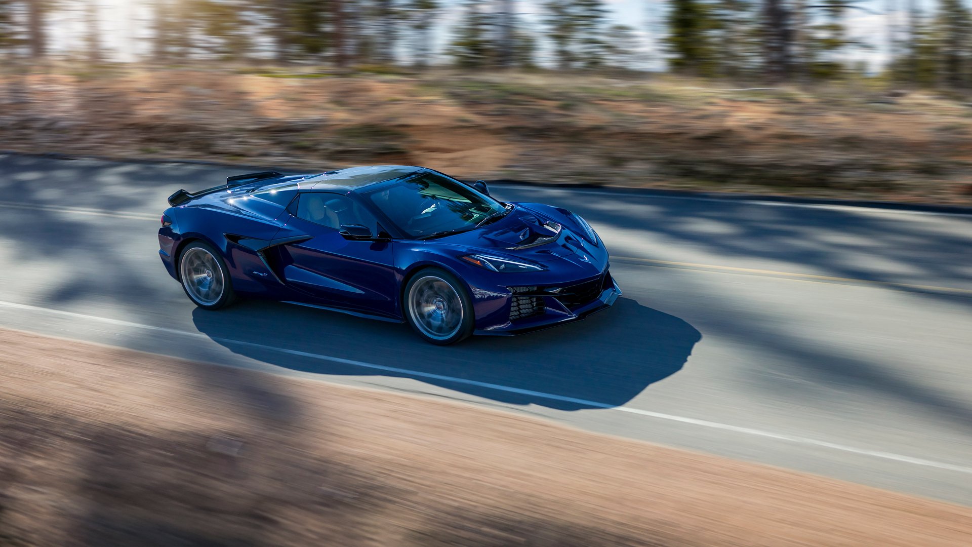 A striking Chevrolet Corvette ZR1 in a dynamic pose, captured on an open road, serving as a stunning HD desktop wallpaper and background.