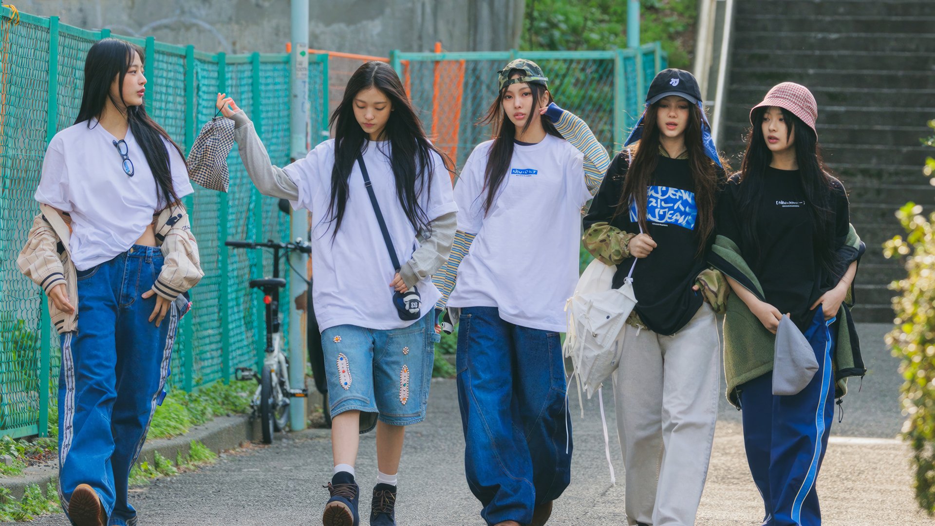 A vibrant 4K Ultra HD wallpaper featuring the K-pop group NewJeans walking together, showcasing their unique style and camaraderie in an urban setting.