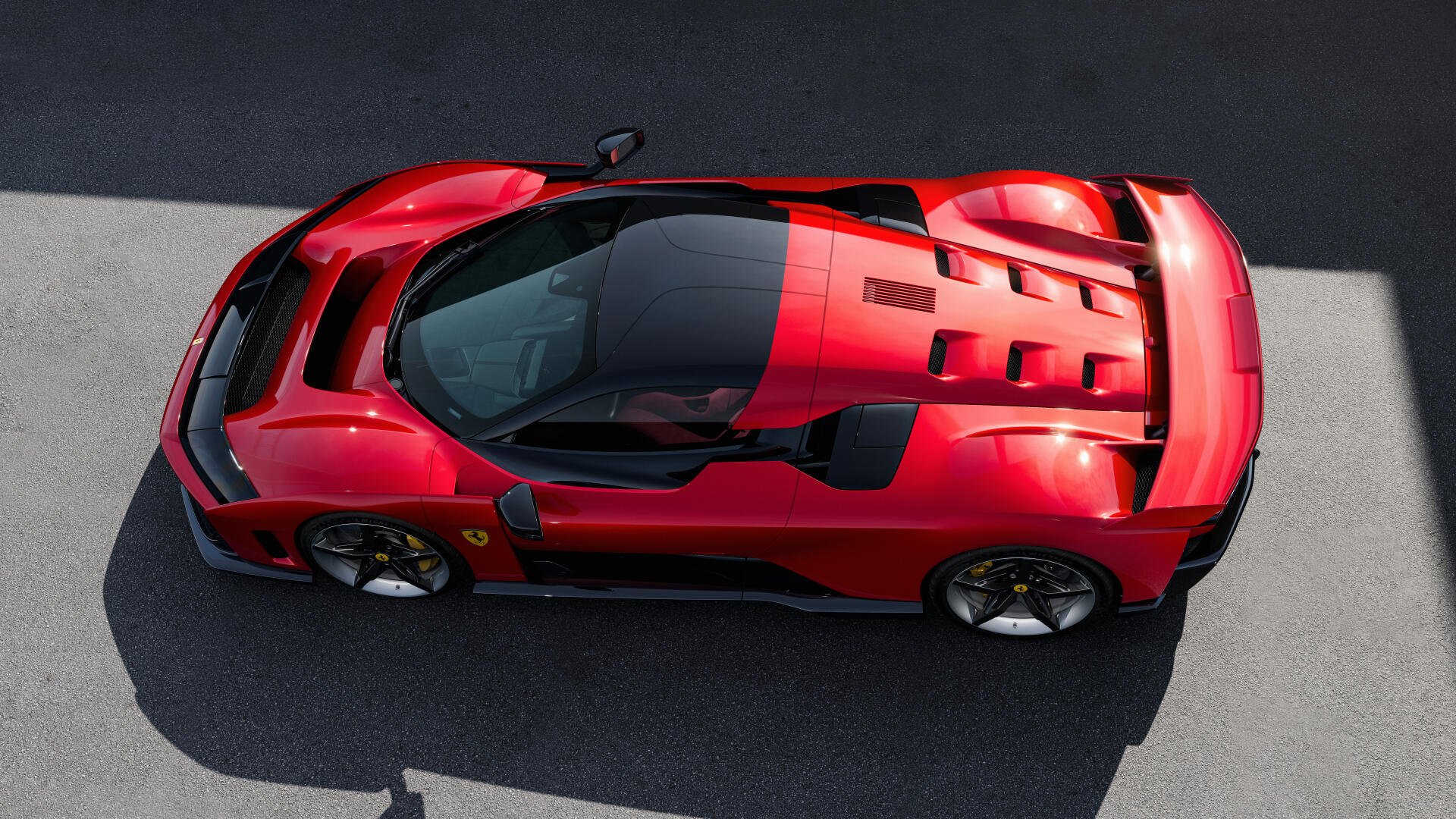 A striking overhead view of a red Ferrari F80, showcasing its sleek design and aerodynamic features, set against a clean background. This image serves as an 8K Ultra HD PC desktop wallpaper.