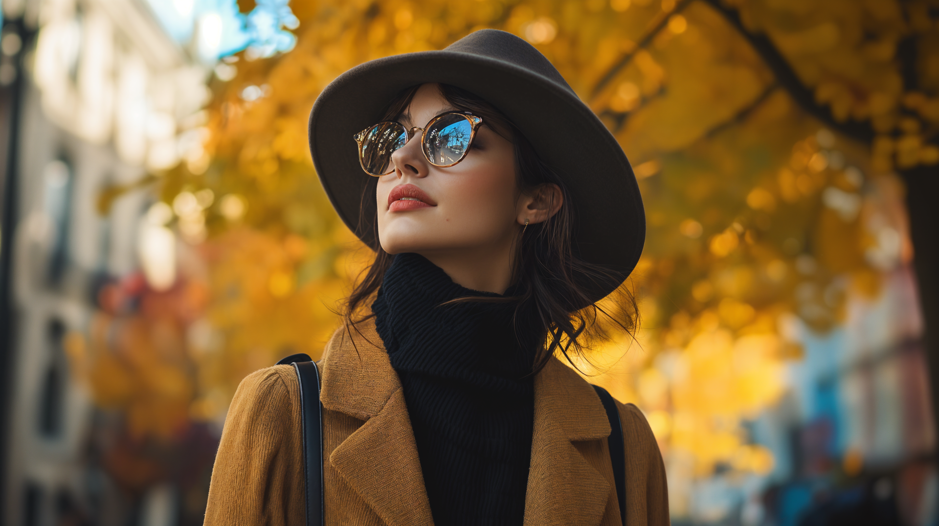 A woman in stylish fall fashion, wearing a hat and sunglasses, stands against a backdrop of vibrant autumn leaves. Captured in stunning 4K Ultra HD, this image embodies seasonal elegance.