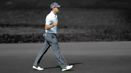HD desktop wallpaper featuring golfer Rory McIlroy in action on the golf course, capturing his dynamic swing and focus in a pristine sports setting.