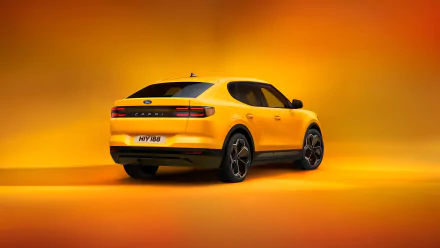 A vibrant yellow Ford Capri showcases its sleek design against an orange background, serving as a striking HD desktop wallpaper.