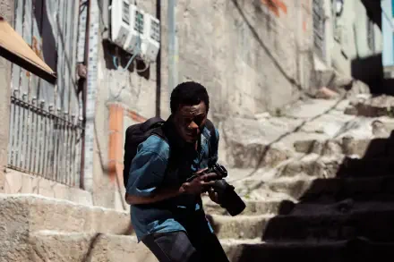 A gripping HD wallpaper from the TV show City of God: The Fight Rages On, featuring a character navigating a gritty urban landscape with a camera in hand.