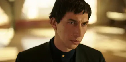 Adam Driver stars in the upcoming movie Megalopolis (2024). The image features him in a striking pose, set against a soft, blurred background.