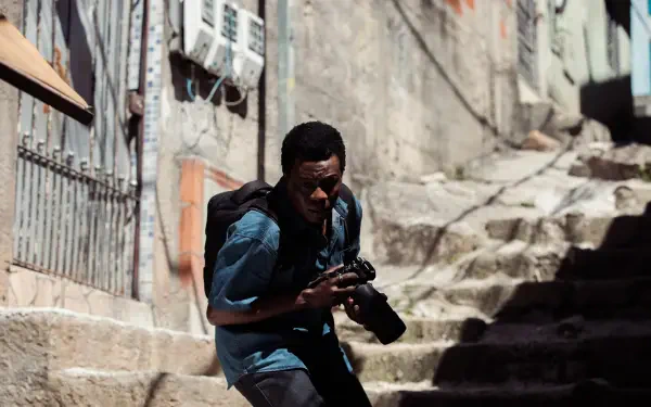 A gripping HD wallpaper from the TV show City of God: The Fight Rages On, featuring a character navigating a gritty urban landscape with a camera in hand.