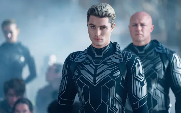 A close-up of Chase Stokes in a futuristic outfit, surrounded by others in a misty setting, from the movie Uglies. High-resolution wallpaper showcasing a dramatic scene.