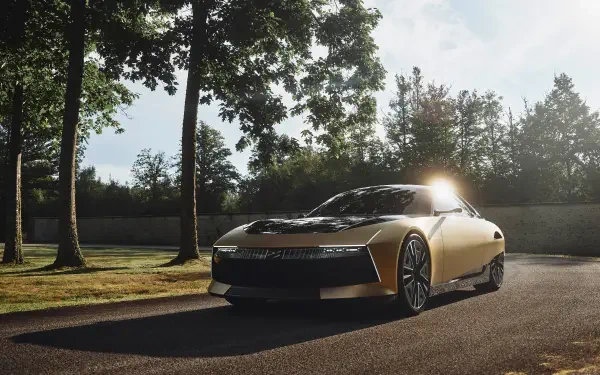 A sleek DS SM Tribute car is illuminated by sunlight as it drives along a tree-lined path, showcasing its modern design in this stunning 4K Ultra HD wallpaper.