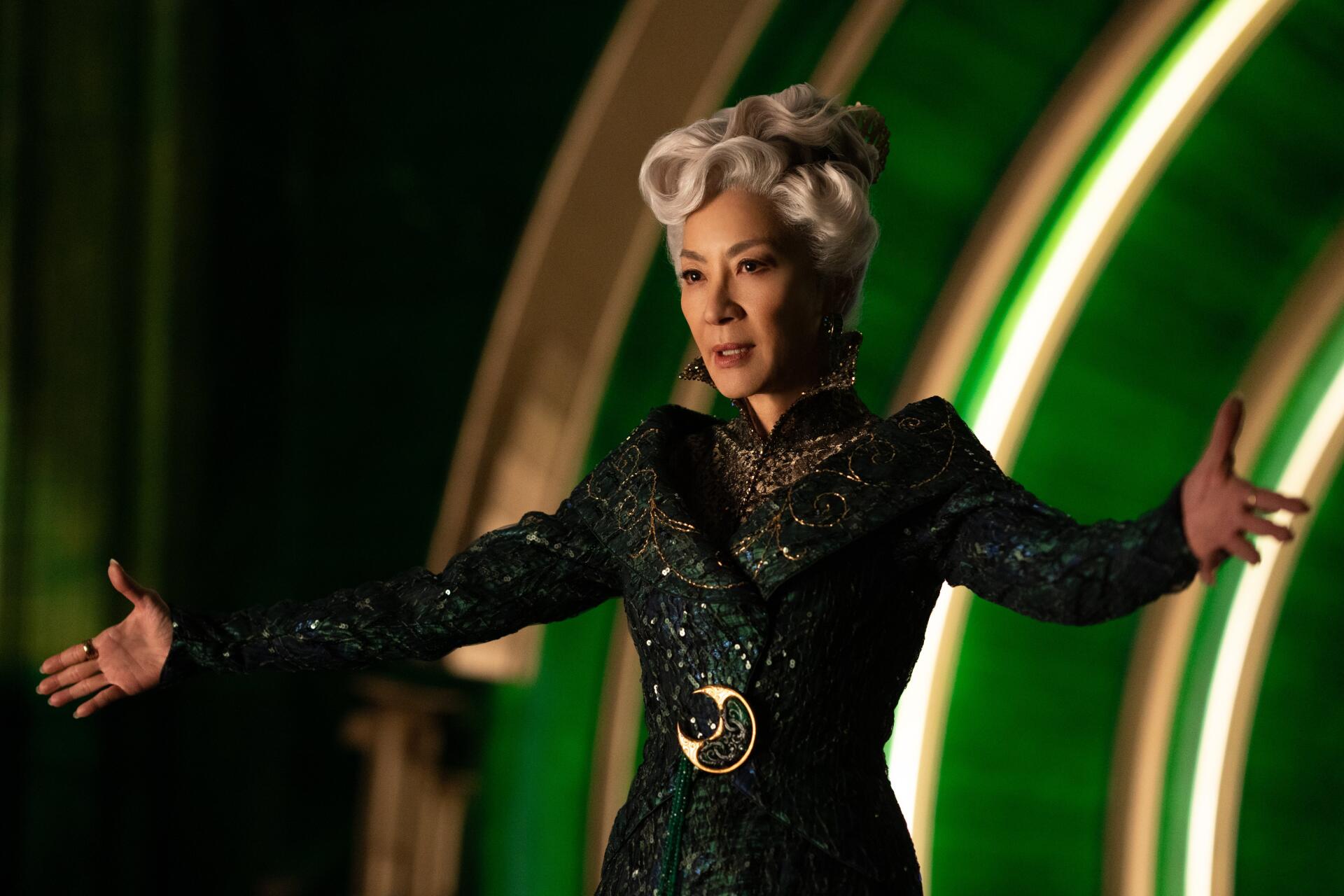 A still from the movie Wicked, featuring Michelle Yeoh in a stunning green and black costume, set against a vibrant background. This image serves as a striking 4K Ultra HD desktop wallpaper.